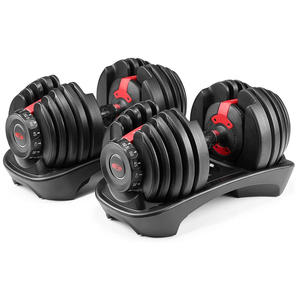 Pair of adjustable dumbbells with red selector dials seated in moulded storage cradles